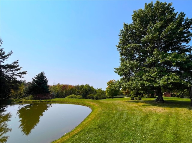 surrounding community featuring a lawn and a water view