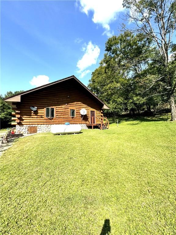 view of property exterior with a wooden deck and a yard