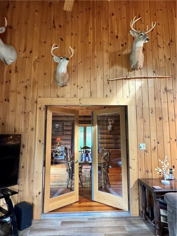 doorway to outside featuring hardwood / wood-style floors and wood walls