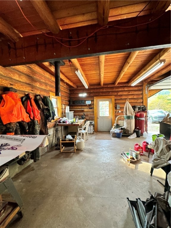 miscellaneous room with concrete flooring and beam ceiling