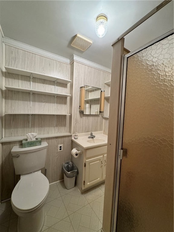 bathroom featuring ornamental molding, vanity, tile patterned flooring, toilet, and a shower with shower door