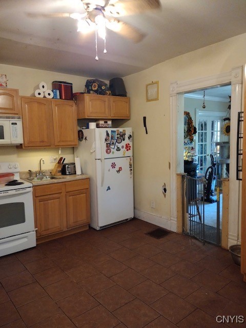 kitchen featuring white appliances, sink, ceiling fan, and dark tile patterned floors