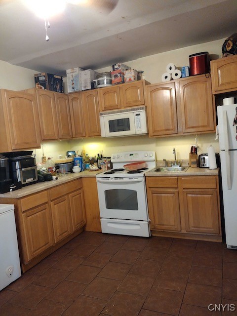 kitchen with white appliances, sink, and dark tile patterned flooring