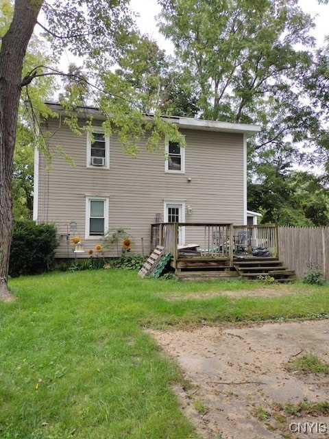 back of property featuring a lawn and a wooden deck