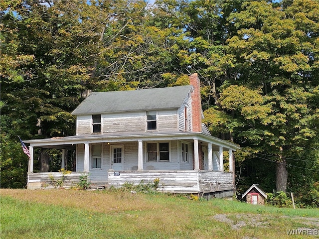 country-style home featuring a shed and covered porch