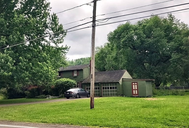 view of front of house with a storage shed and a front lawn