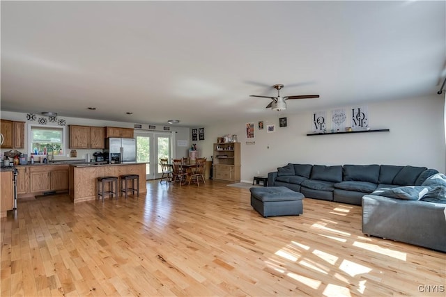 living room with french doors, light hardwood / wood-style flooring, plenty of natural light, and ceiling fan