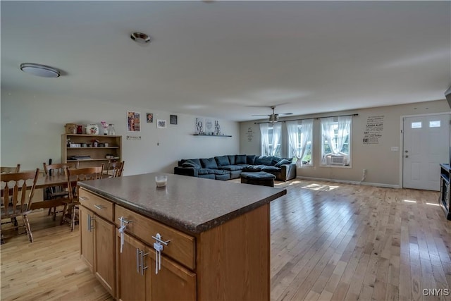 kitchen with ceiling fan, light hardwood / wood-style flooring, and a kitchen island