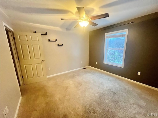 unfurnished room with ceiling fan and light colored carpet