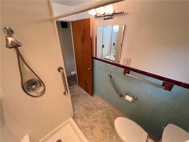 bathroom featuring a shower, toilet, and tile walls