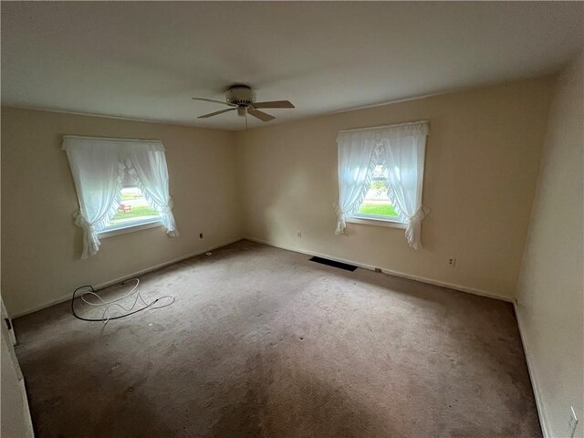 carpeted spare room with ceiling fan and a healthy amount of sunlight