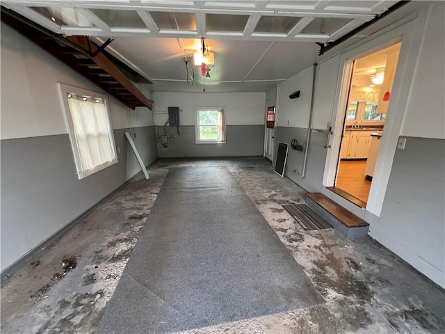 garage featuring a garage door opener, sink, and electric panel