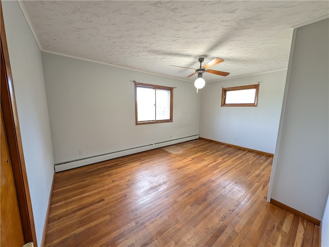 spare room with a textured ceiling, hardwood / wood-style flooring, ceiling fan, and a baseboard radiator