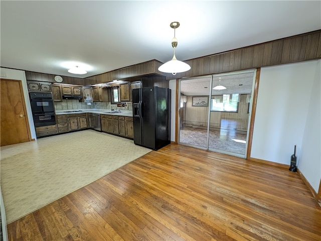 kitchen featuring sink, dark brown cabinets, backsplash, black appliances, and light wood-type flooring