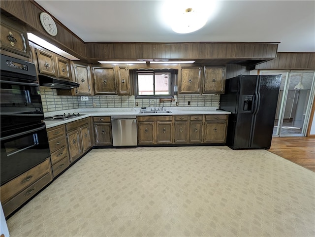 kitchen featuring decorative backsplash, black appliances, dark brown cabinetry, and sink