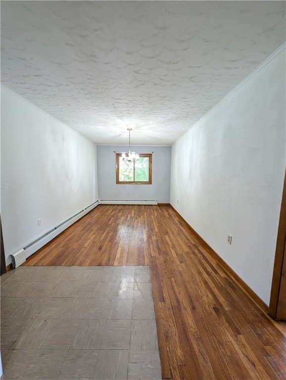 spare room with baseboard heating, crown molding, a textured ceiling, and hardwood / wood-style floors