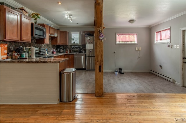 kitchen featuring appliances with stainless steel finishes, a healthy amount of sunlight, light hardwood / wood-style flooring, and a baseboard radiator