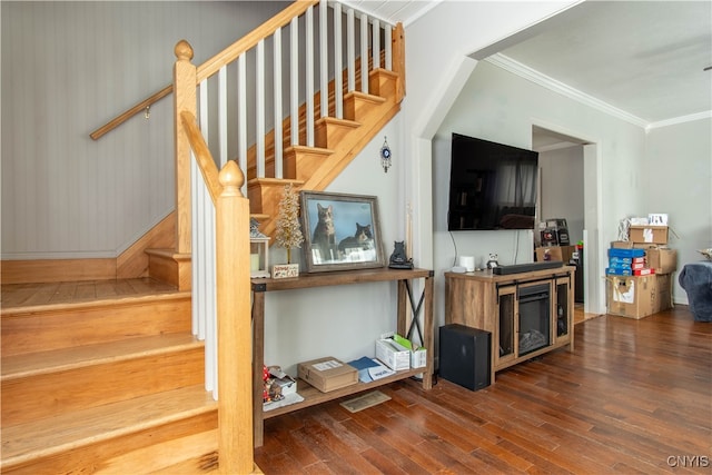 stairs featuring ornamental molding, a fireplace, and hardwood / wood-style floors