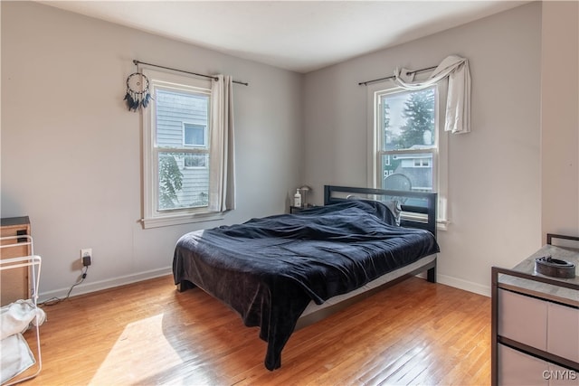 bedroom with multiple windows and light wood-type flooring