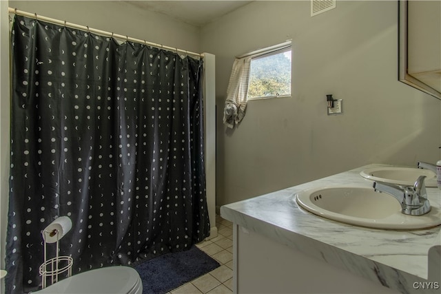 bathroom featuring tile patterned flooring, walk in shower, vanity, and toilet