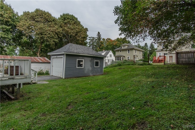 view of yard with a garage and an outbuilding