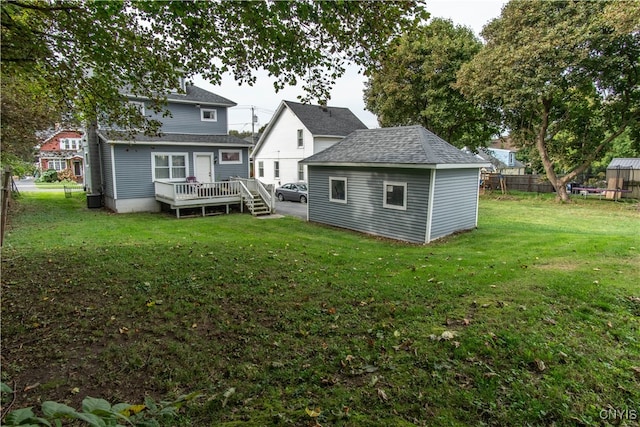 rear view of house featuring a storage shed, a deck, and a lawn