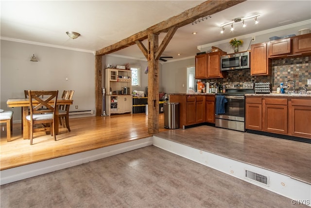 kitchen with appliances with stainless steel finishes, tasteful backsplash, ornamental molding, sink, and a baseboard heating unit