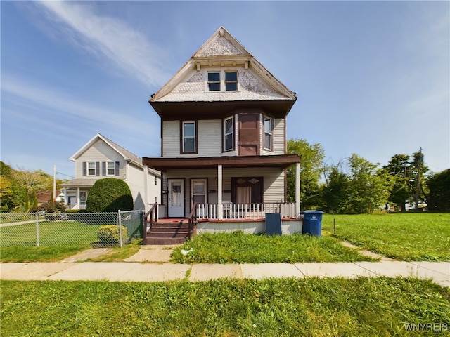 victorian-style house with a front lawn and a porch