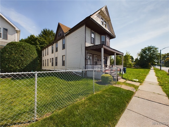 view of side of property with a porch and a lawn