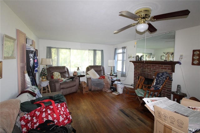 living room with a fireplace, dark wood-type flooring, and ceiling fan