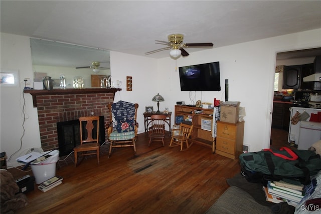 living room with a brick fireplace, ceiling fan, and dark hardwood / wood-style flooring