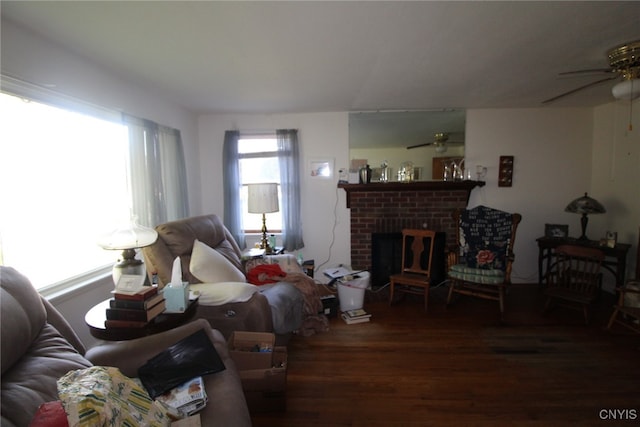 living room with a brick fireplace, ceiling fan, and dark hardwood / wood-style flooring