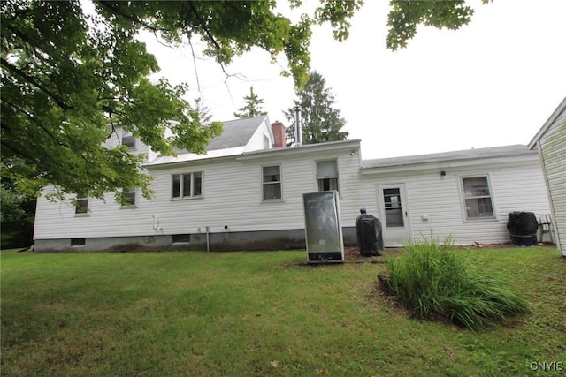 rear view of property with a yard and a chimney