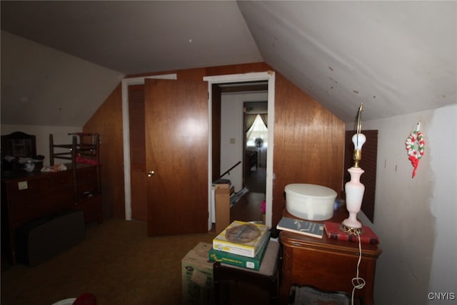 bonus room featuring lofted ceiling and wood walls