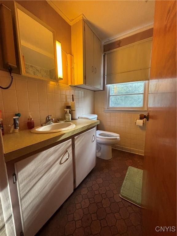 bathroom featuring tile walls, vanity, and toilet