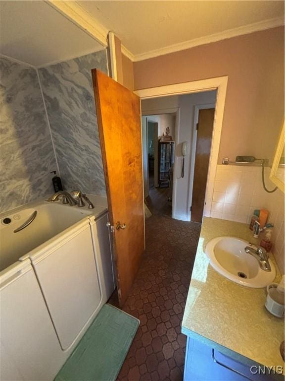 full bath featuring ornamental molding, a bathtub, and vanity