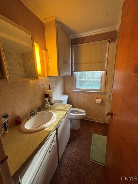 bathroom with toilet, tile walls, backsplash, and vanity