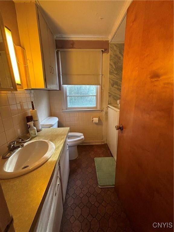 bathroom featuring tile walls, vanity, and toilet