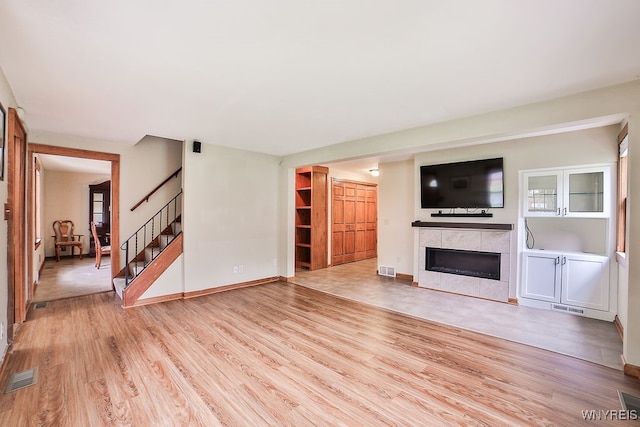 unfurnished living room with light wood-type flooring and a fireplace