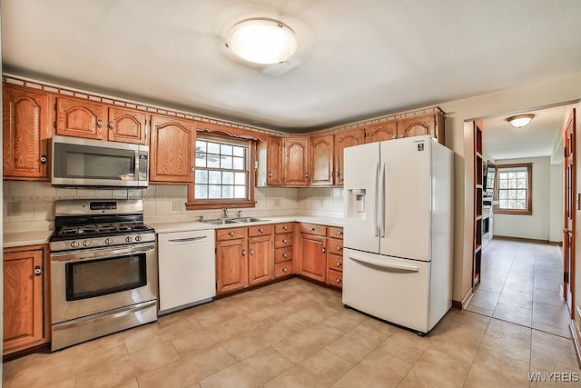 kitchen featuring light tile patterned floors, appliances with stainless steel finishes, sink, and tasteful backsplash