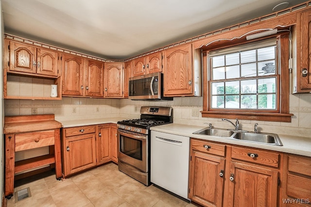 kitchen with sink, stainless steel appliances, and tasteful backsplash