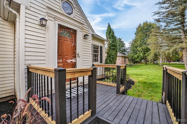 wooden deck featuring a lawn