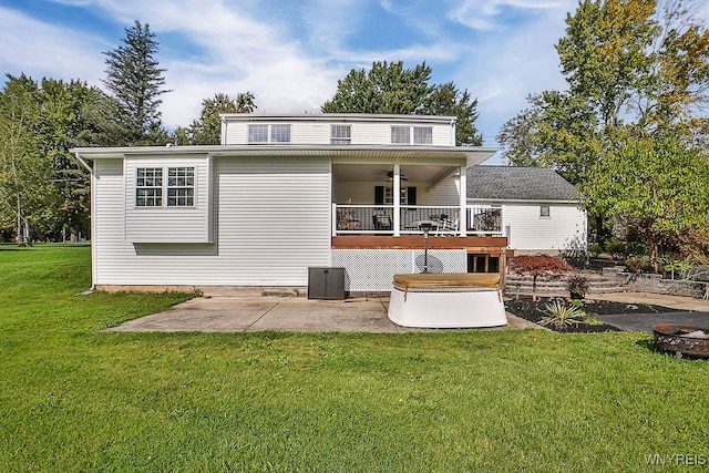 rear view of property with central AC unit, a deck, and a yard