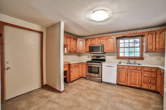 kitchen featuring stainless steel appliances, sink, and tasteful backsplash