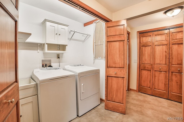 clothes washing area with cabinets and washing machine and clothes dryer