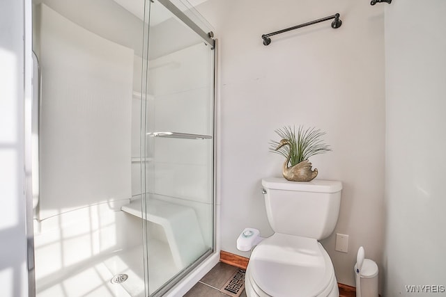 bathroom featuring toilet and an enclosed shower