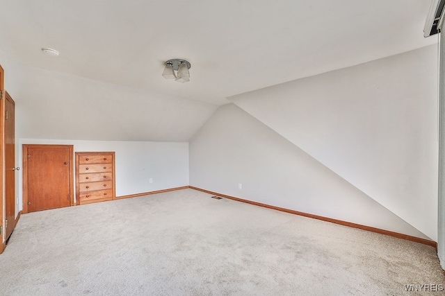 bonus room with vaulted ceiling, carpet floors, and a wall mounted air conditioner