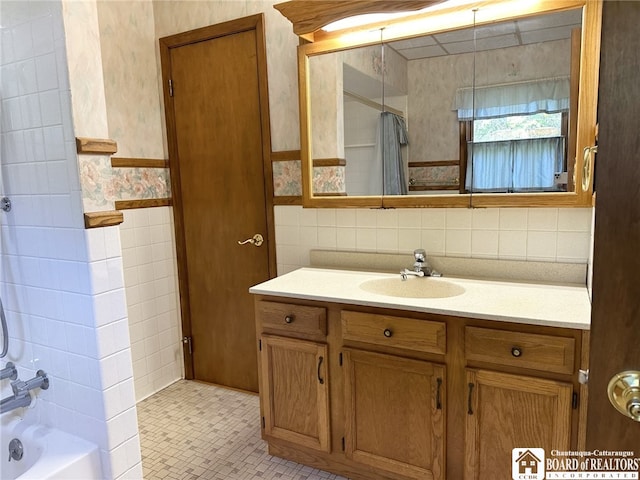 bathroom featuring vanity, tile walls, and shower / tub combo with curtain