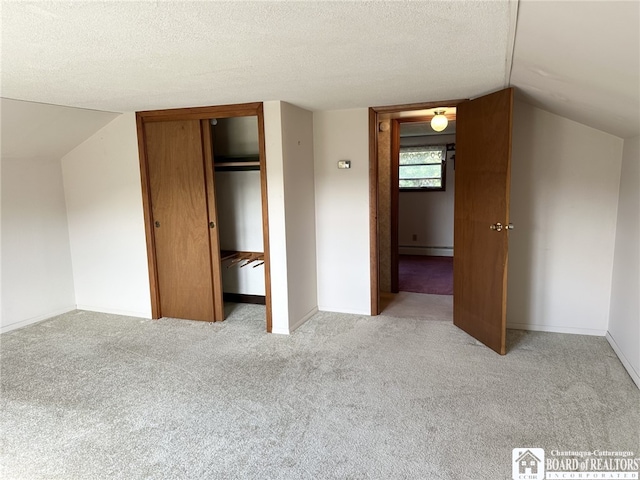 unfurnished bedroom with light colored carpet, a baseboard radiator, a closet, and lofted ceiling