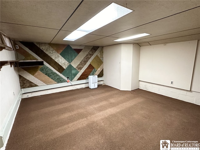 basement featuring a paneled ceiling and carpet flooring